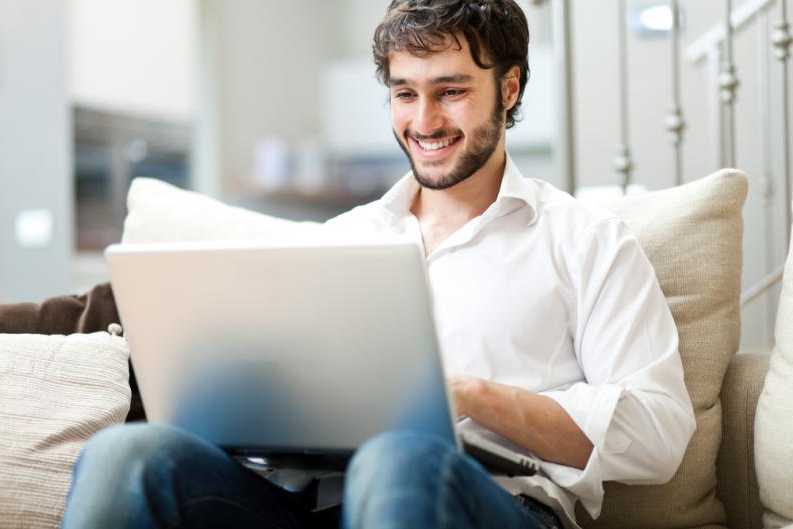 Hombre feliz navegando en línea portátil